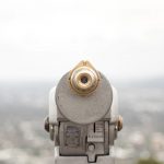 Coin operated telescope looking over out of focus city