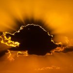 Sun casting shadows around a cloud